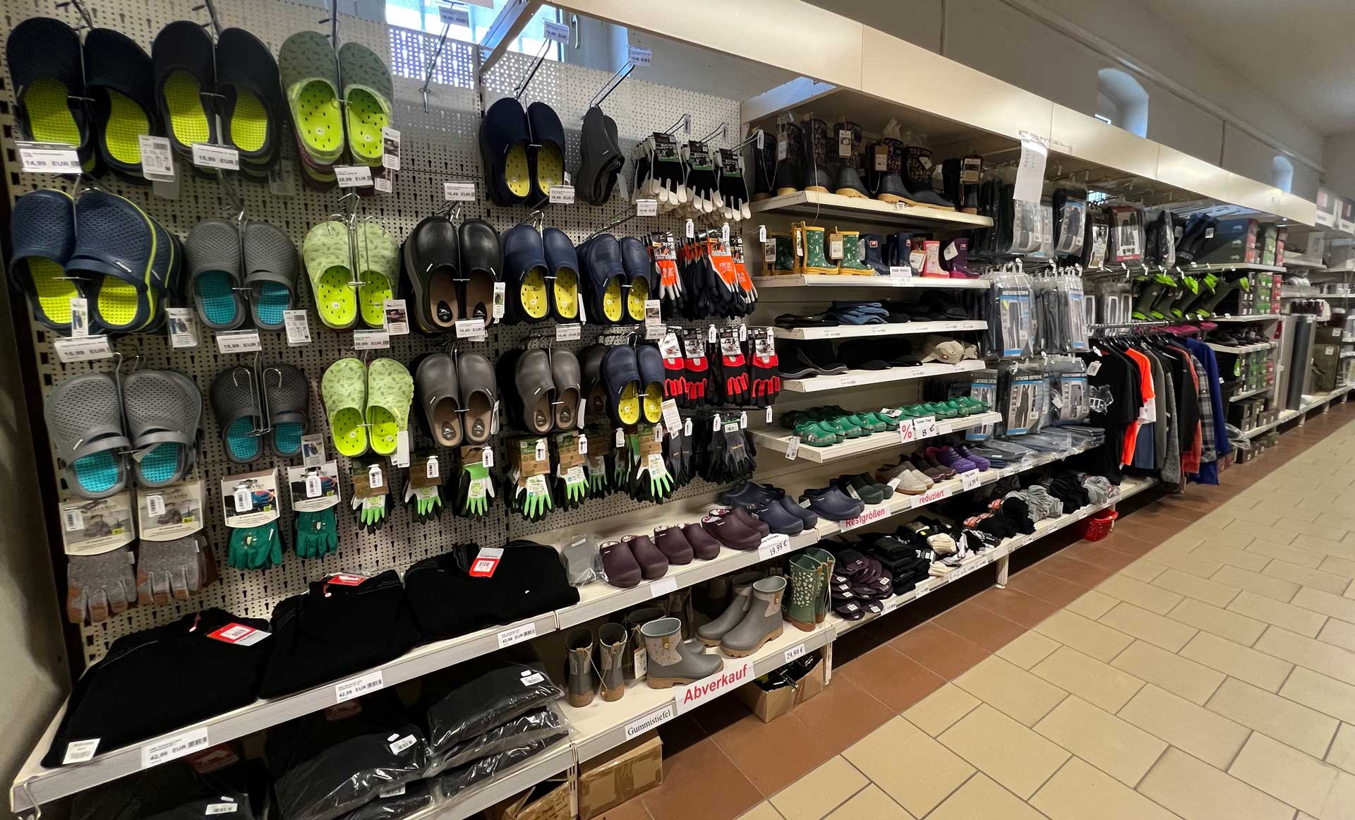 Ein Geschäftsgang mit Hausschuhen und Kleidung in verschiedenen Farben und Stilen.