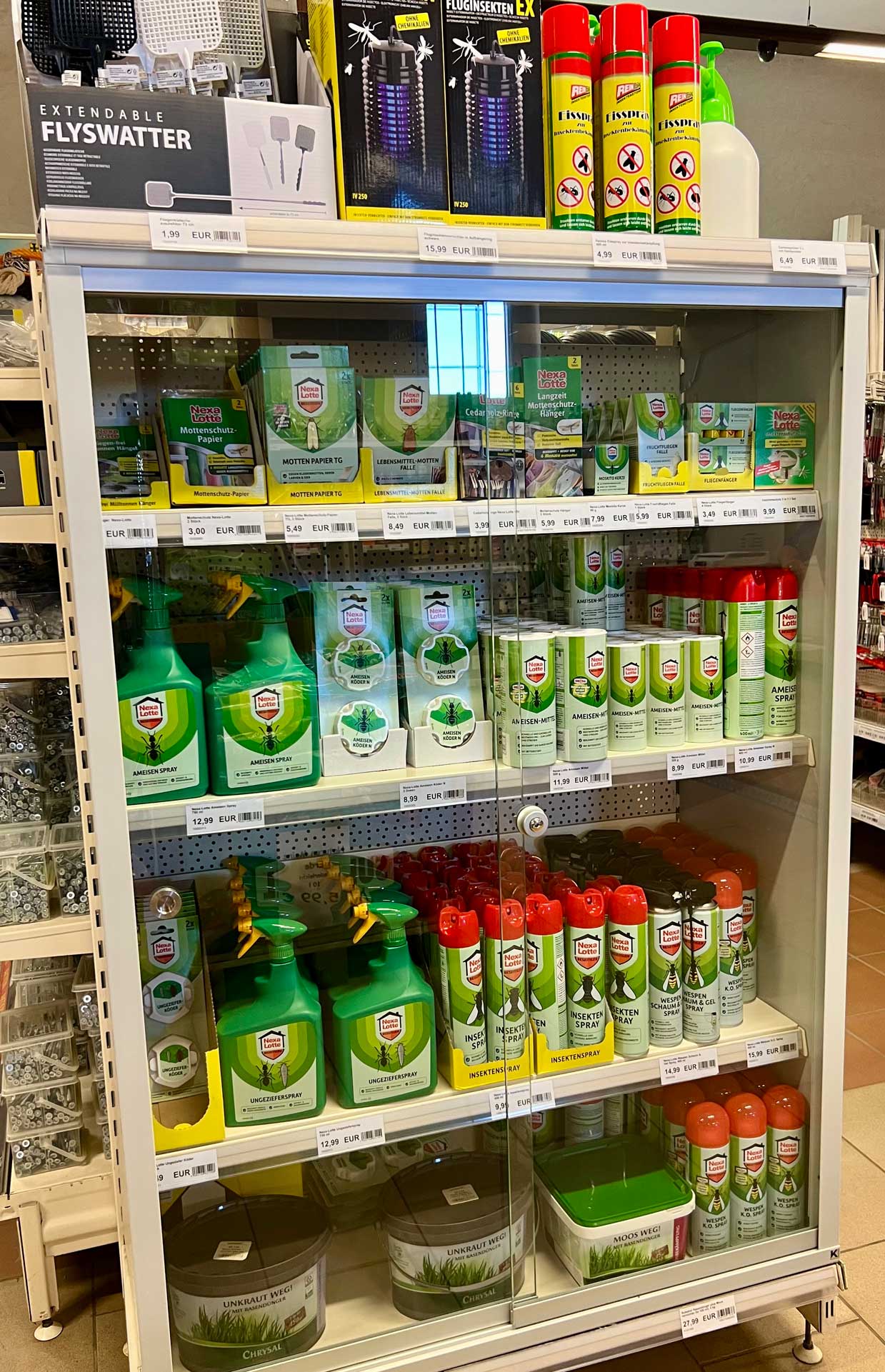Ein Regal mit verschiedenen Insektenschutzprodukten in Grün- und Rottönen.