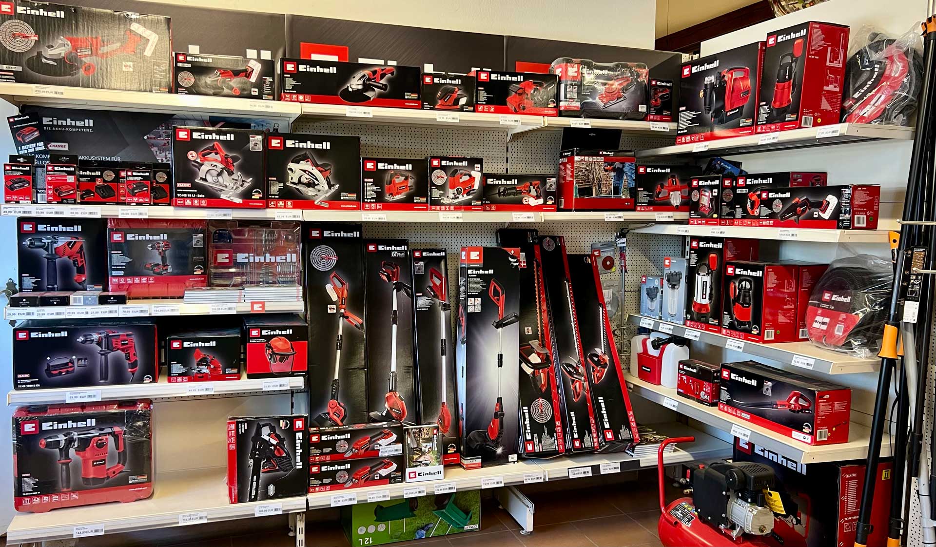 Regale mit verschiedenen Werkzeug-Verpackungen in Rot und Schwarz in einem Geschäft.